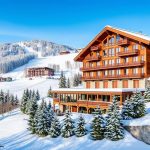 Generate an image of the MK Resort Bukovel main building with a ski slope in the background.