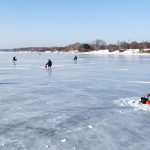 Frozen Kyiv Reservoir in winter 2026 with anglers fishing through ice holes