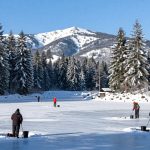 Заснеженное озеро в Карпатах с рыбаками на льду зимой 2026