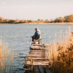 Рибалка вбрід на кам’янистій річці
