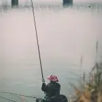 Рибалка вбрід на зеленій річці
