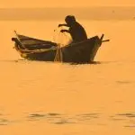 Рибалка з вудкою на осінній річці